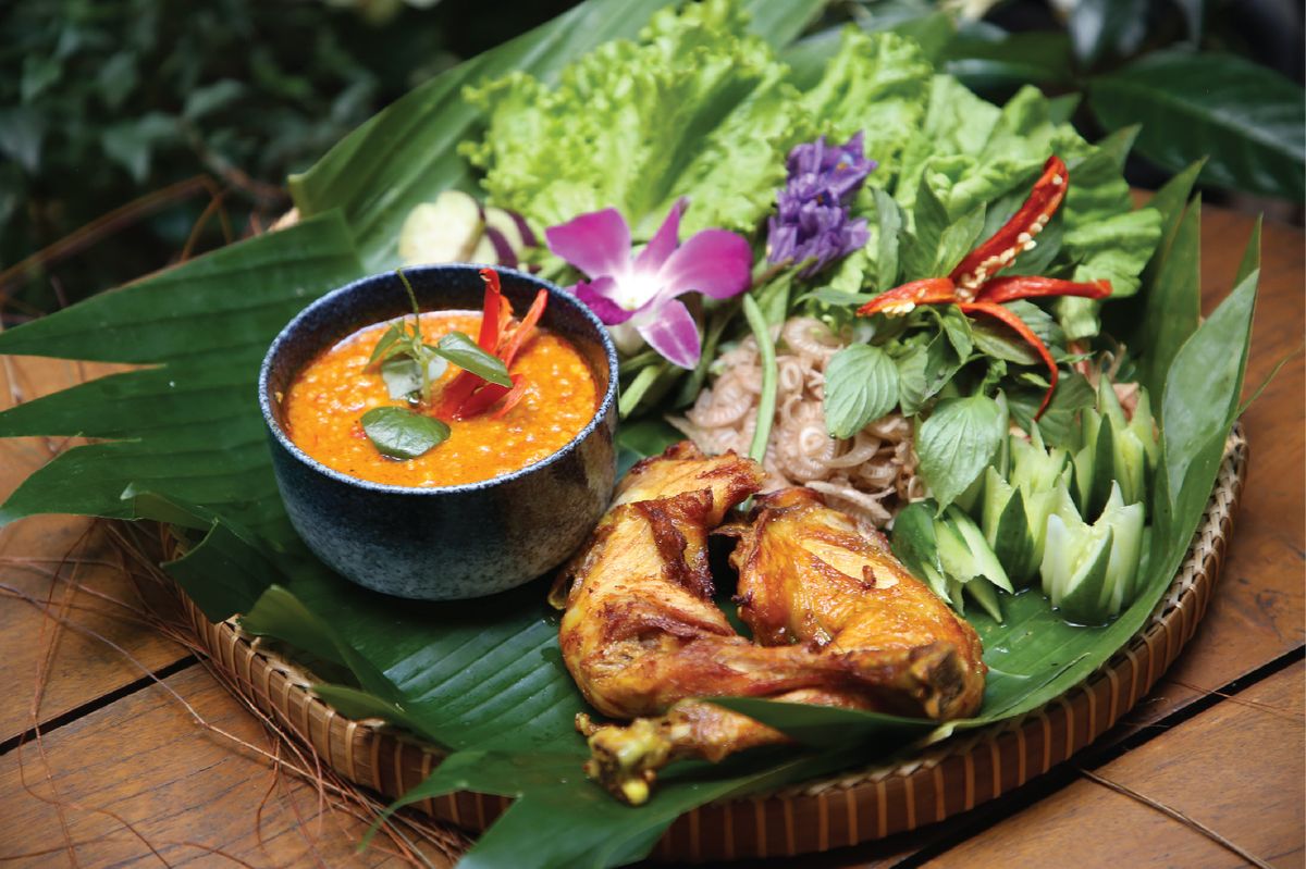 Khmer-style chicken with fresh herbs, chilli and banana leaf presentation